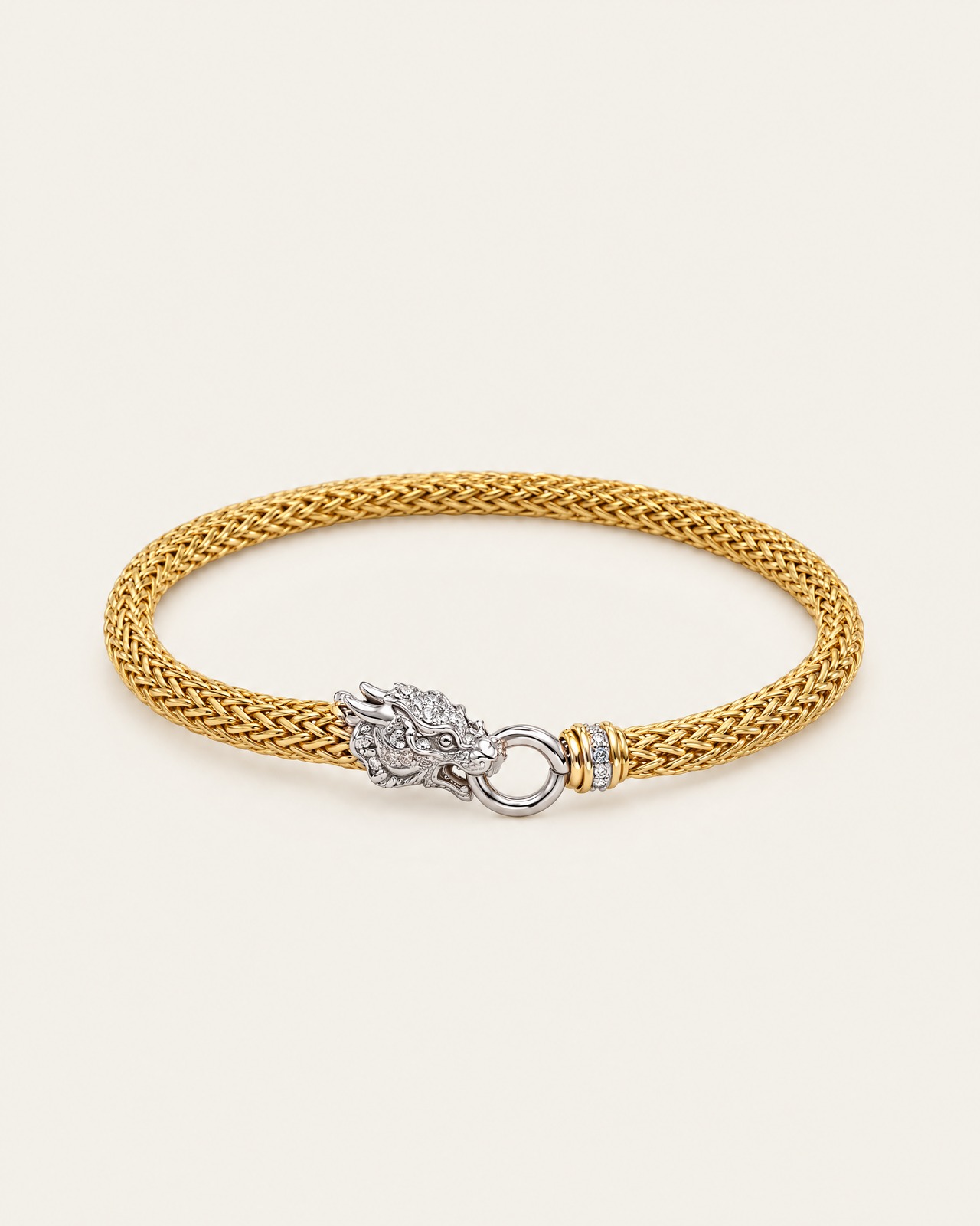 The gold-tone woven dragon bracelet with a finely woven chain and silver-tone dragon head, on a light background