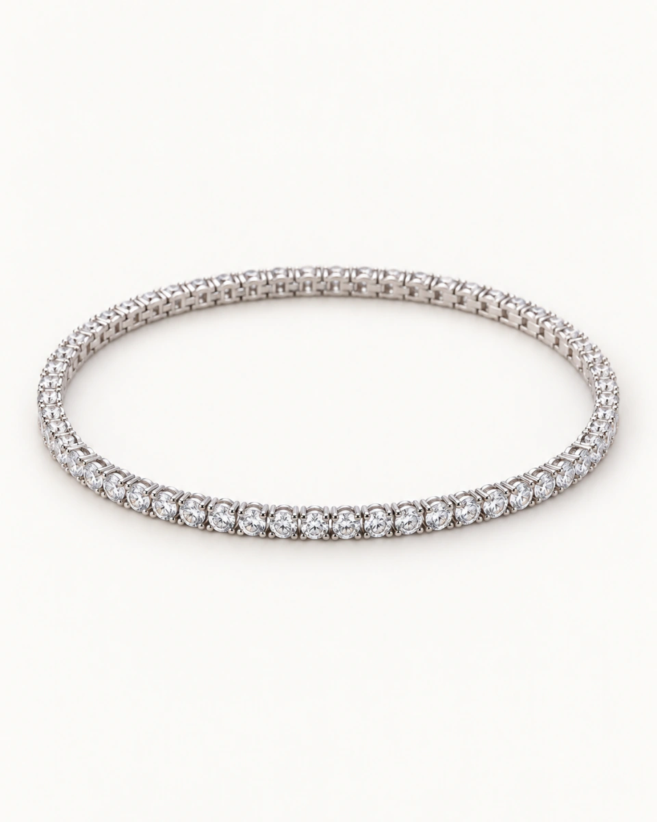 The clear tennis bracelet with one row of round clear stones in silver-tone settings, on a light background